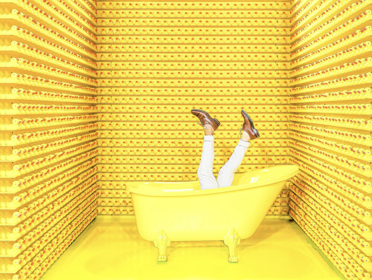 A pair of feet coming out of a yellow bathtub